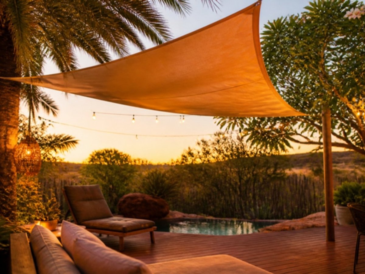 Shade sail over a backyard deck at sunset